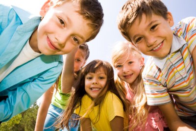 Lachende Kindergruppe sieht in die Kamera